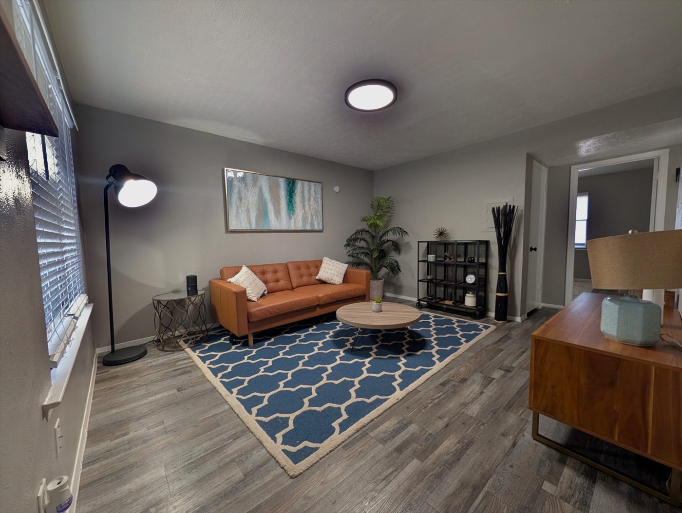 Living room with plank flooring, leather sofa and round coffee table